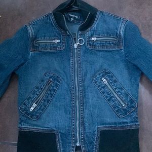 A Bebe jean jacket with a lot of zippers